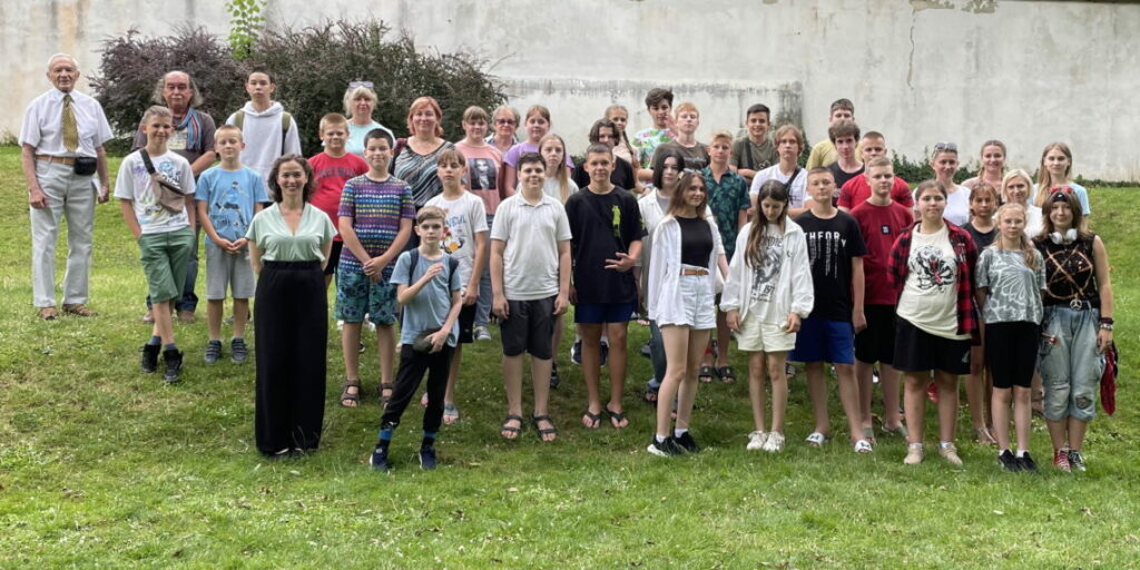 grupa młodzieży pozuje na trawniku